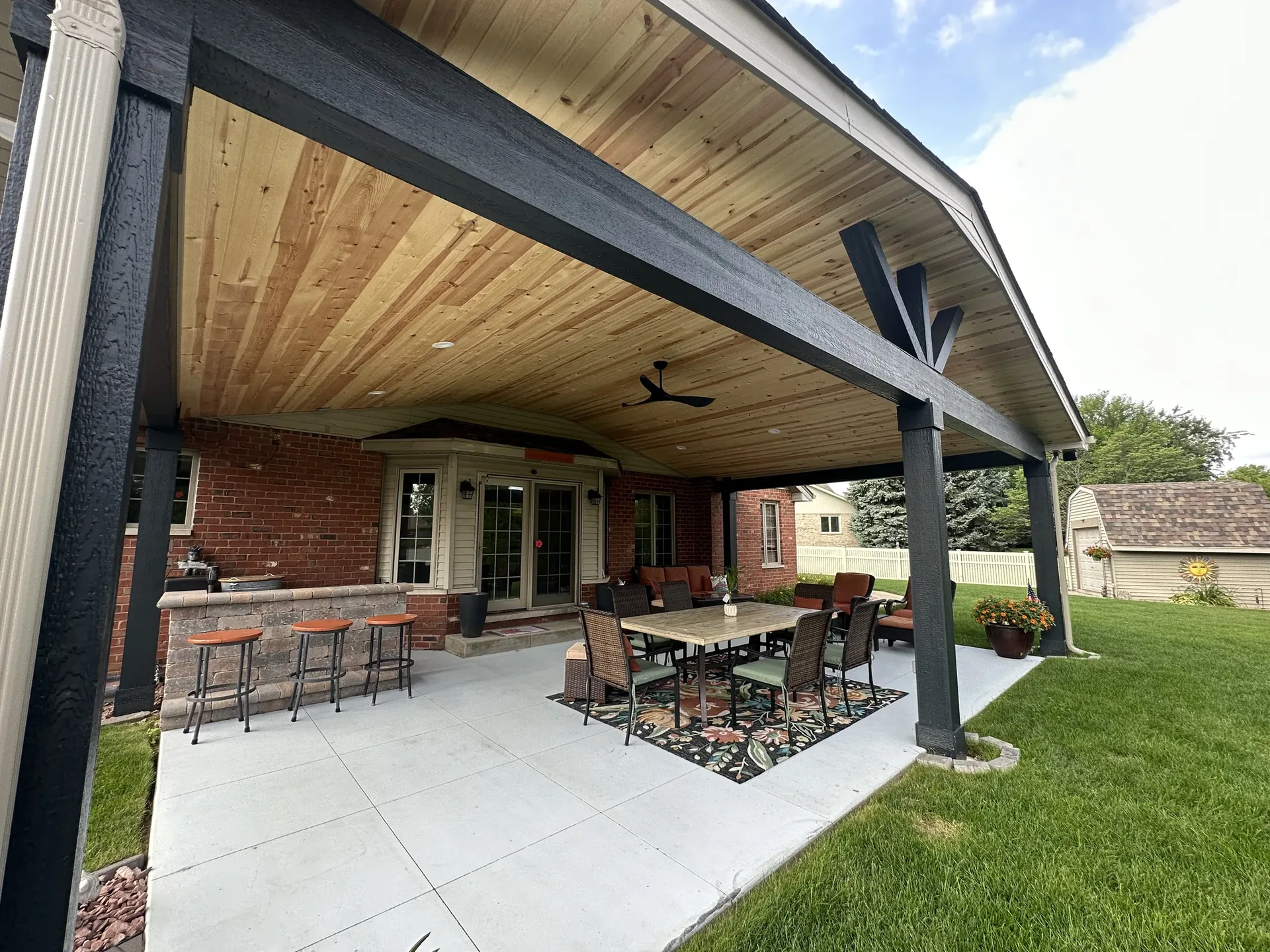 Covered back patio with tongue-and-groove wood ceiling and outdoor furniture