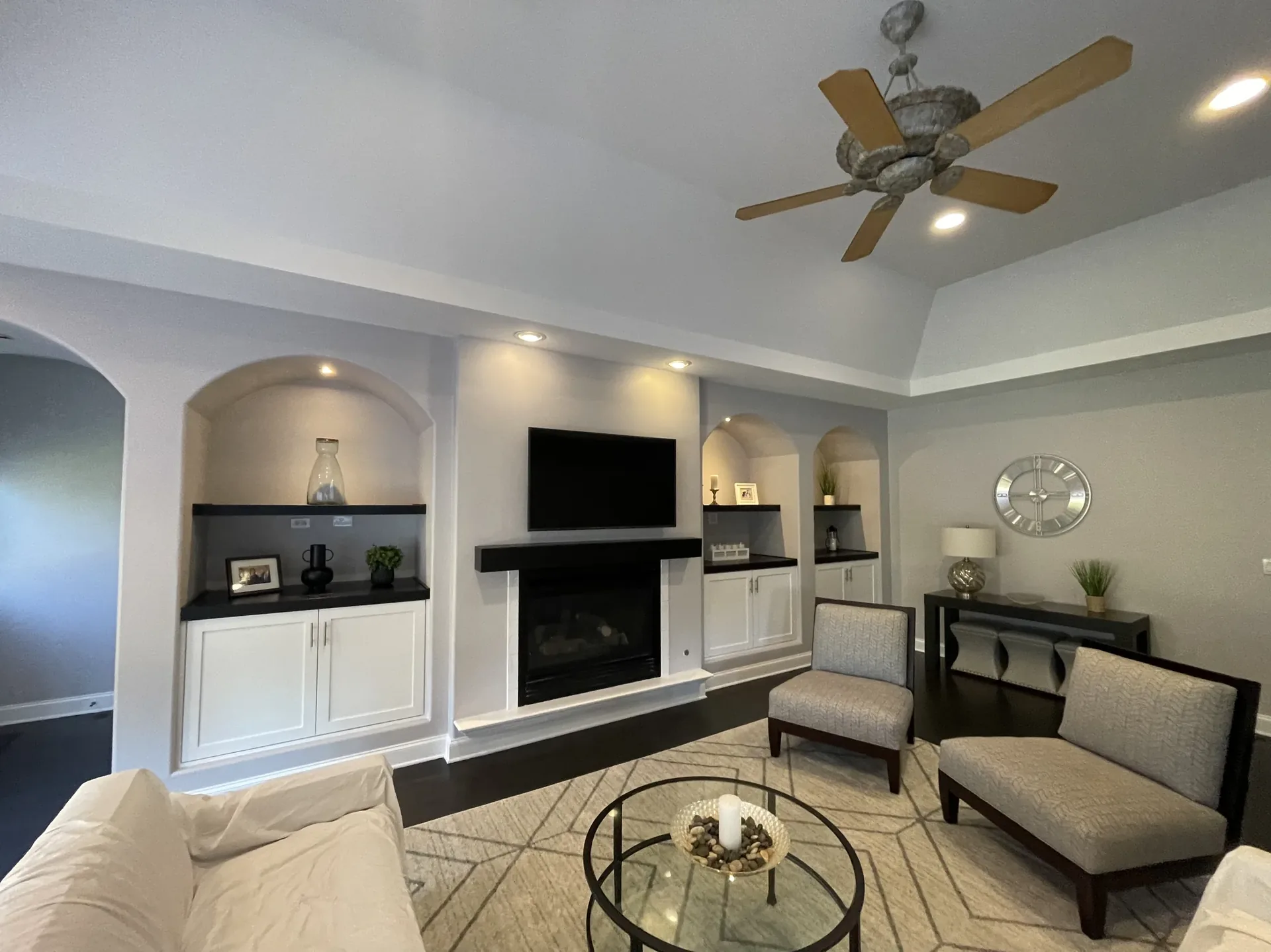 Finished living room with vaulted ceiling, fireplace, and built-ins