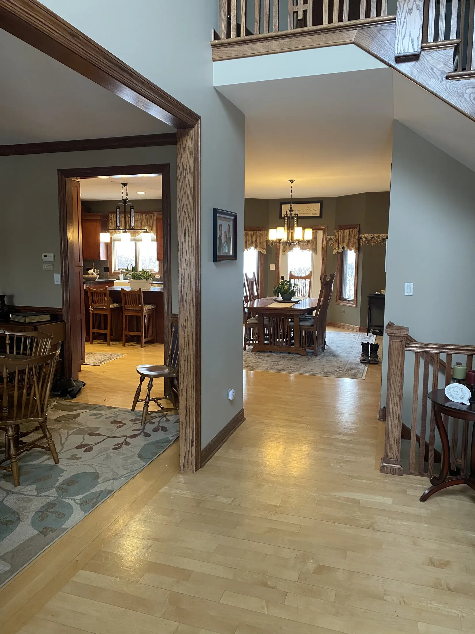 Finished foyer with hardwood floors looking into dining and kitchen