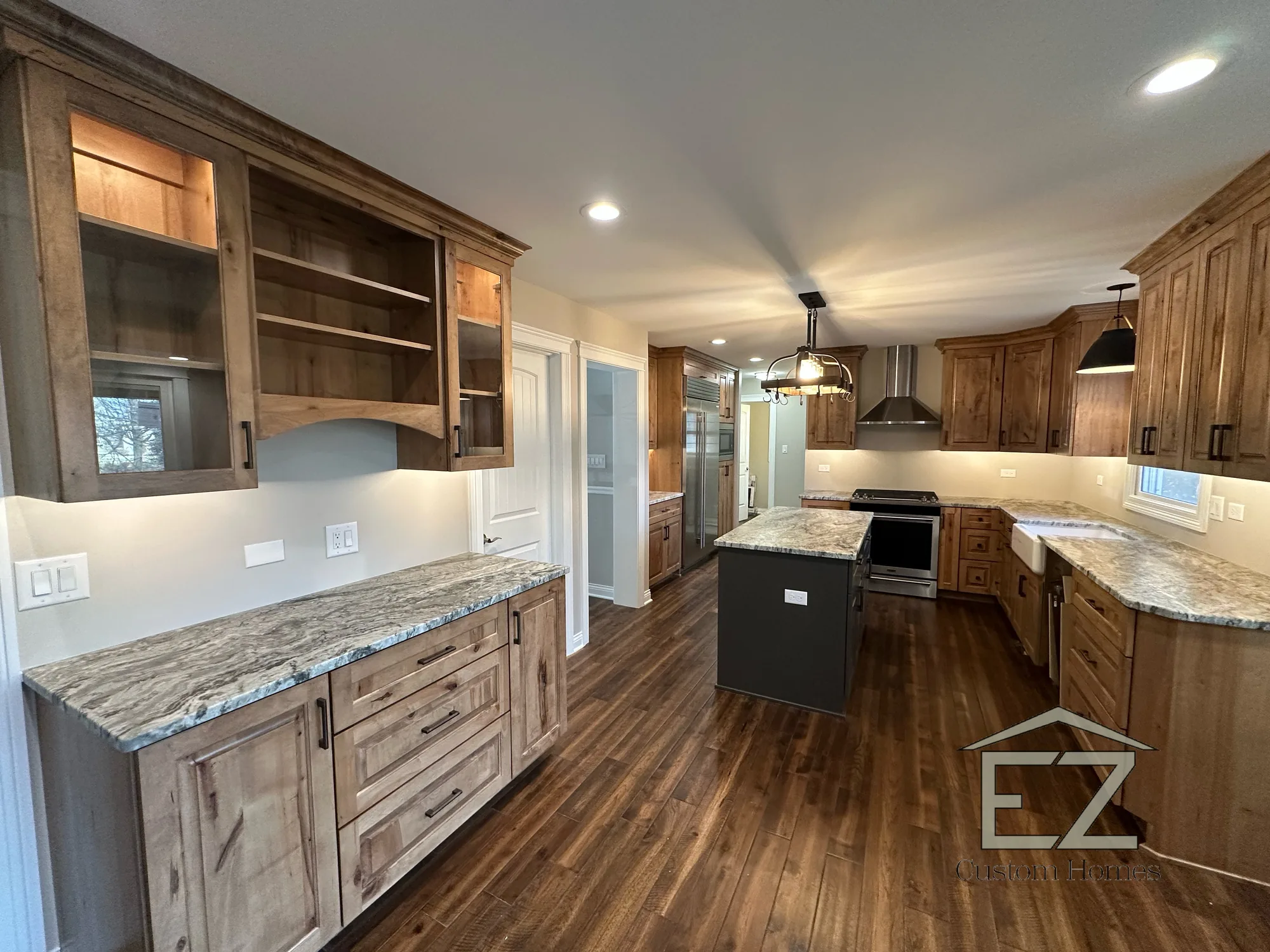 Finished kitchen with beamed ceiling, island, and stainless appliances